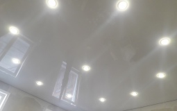 Белый глянцевый потолок со светильниками  в гостиную